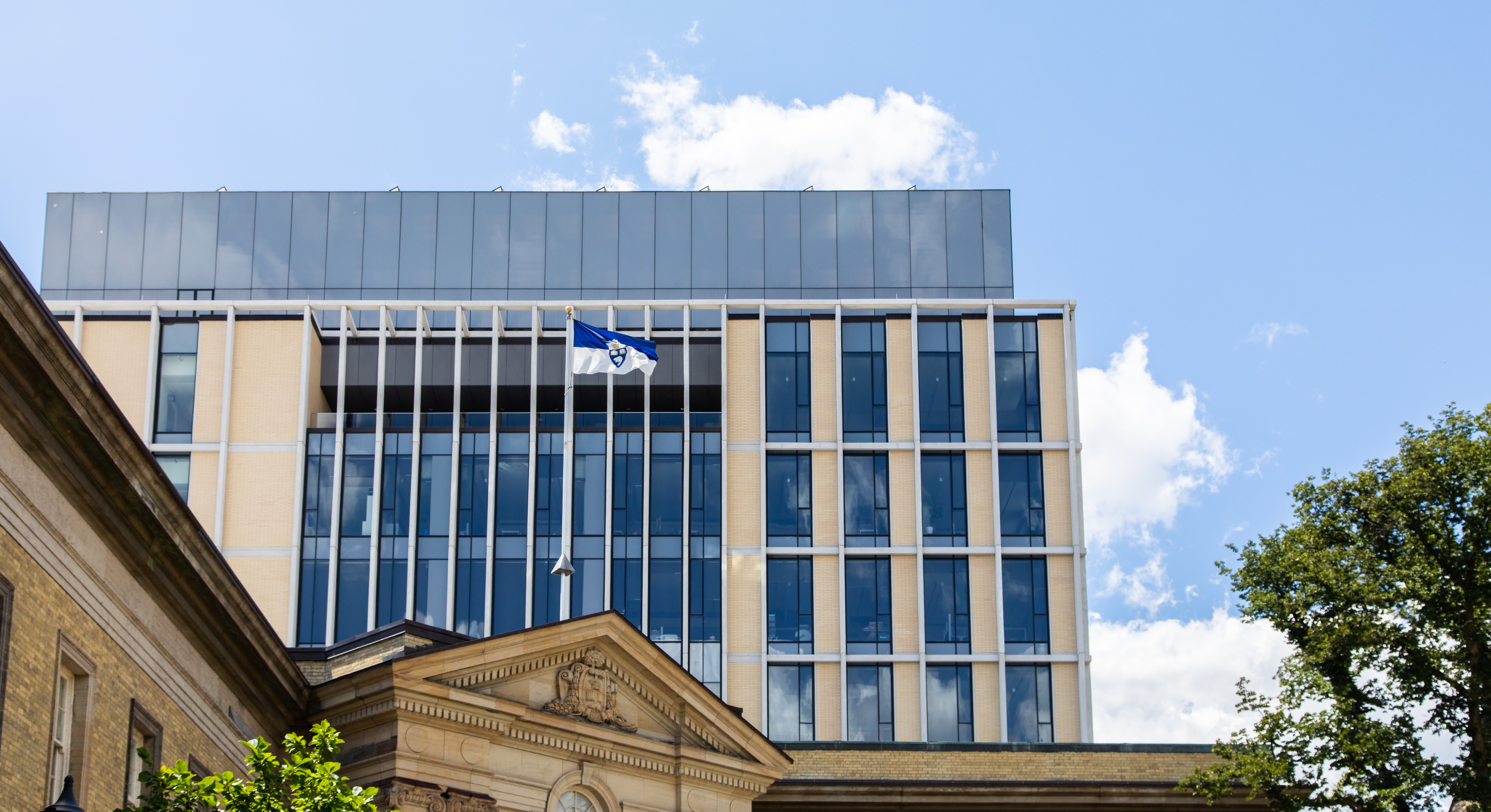 Image shows Myhal Centre and Convocation Hall with the U of T flag.